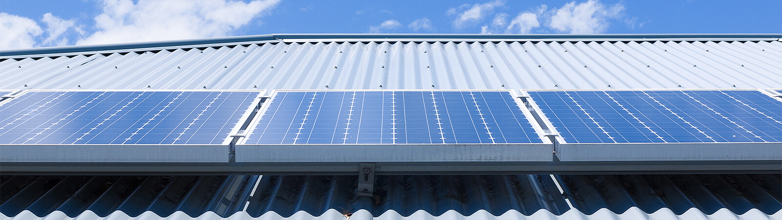 Close up of solar panels on metal roof with sky