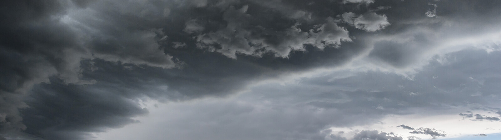 Hands holding large pile of hailstones that have damaged roof